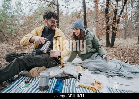 Junge Freunde, die ein gemütliches Picknick in einer malerischen Waldlandschaft genießen Stockfoto