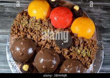 Kairo, Ägypten, 1. Juni 2025: Eiskuchen, auf einer Biskuitschicht, belegt mit Oreo, Schokoladenkugeln und Sahne, Haselnüssen und Karamellsauce und Brocken Stockfoto