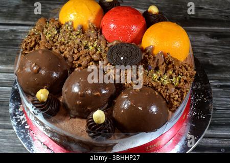 Kairo, Ägypten, 1. Juni 2025: Eiskuchen, auf einer Biskuitschicht, belegt mit Oreo, Schokoladenkugeln und Sahne, Haselnüssen und Karamellsauce und Brocken Stockfoto
