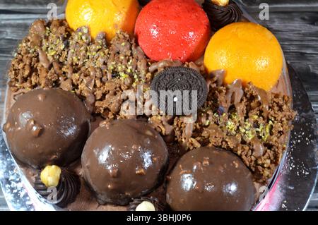 Kairo, Ägypten, 1. Juni 2025: Eiskuchen, auf einer Biskuitschicht, belegt mit Oreo, Schokoladenkugeln und Sahne, Haselnüssen und Karamellsauce und Brocken Stockfoto