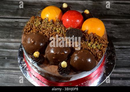 Kairo, Ägypten, 1. Juni 2025: Eiskuchen, auf einer Biskuitschicht, belegt mit Oreo, Schokoladenkugeln und Sahne, Haselnüssen und Karamellsauce und Brocken Stockfoto