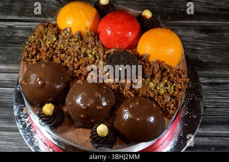 Kairo, Ägypten, 1. Juni 2025: Eiskuchen, auf einer Biskuitschicht, belegt mit Oreo, Schokoladenkugeln und Sahne, Haselnüssen und Karamellsauce und Brocken Stockfoto