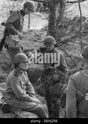 Reeanctors der Roten Armee aus dem 2. Weltkrieg entspannen sich in einem Graben in einem Wald im No Mans Land 2024 in der Bodrhyddan Hall Stockfoto