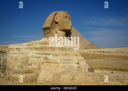 Eine fesselnde Nahaufnahme der Großen Sphinx von Gizeh mit der Pyramide von Khufu, die in Ägypten im Hintergrund steht Stockfoto