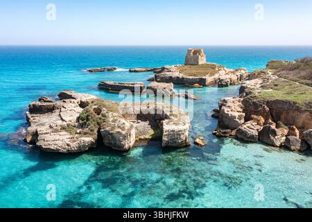 Der Küstenturm wacht über kristallklares Wasser und Felsformationen in Salento. Stockfoto