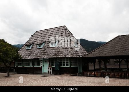 Traditionelles Holzrestaurant im Dorf Drvengrad mit mintfarbenen Fenstern und Holzschindeln. Mokra gora, Serbien - 15. Mai 2025. Stockfoto