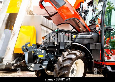 Reparaturszene für landwirtschaftliche Geräte mit geöffneter Traktorhaube auf landwirtschaftlichen Flächen Stockfoto