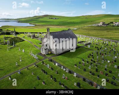 Tingwall Kirk eingebettet in das malerische Tingwall Valley, Shetland, eine historische Pfarrkirche, die an klaren Tagen zwischen sanften Hügeln und ruhigen Lochs liegt. Stockfoto