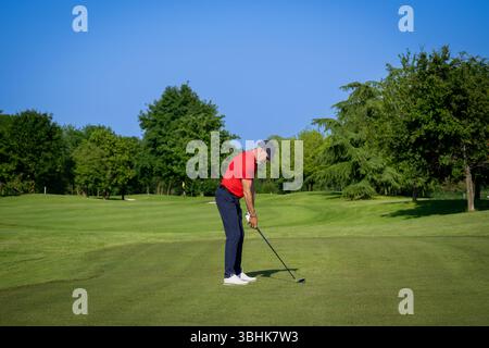 Golfspieler konzentrieren sich, machen sich bereit, seinen Club an einem schönen, sonnigen Tag auf dem Golfplatz zu schwingen Stockfoto