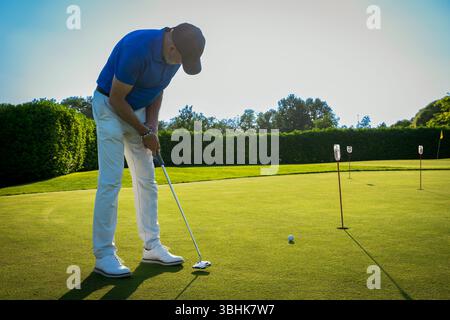 Golfspieler, die an einem sonnigen Tag auf dem Grün eines wunderschönen Golfplatzes stehen Stockfoto