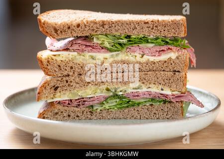 UK. Ein großzügiges Pastrami-Sandwich im New Yorker Stil, serviert auf braunem Roggenbrot mit Salat und Mayo-Dressing. Stockfoto