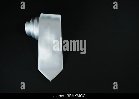 Eine Krawatte rollte auf schwarzem Hintergrund Nahaufnahme Stockfoto