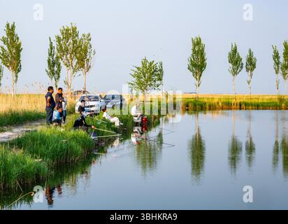 Leute aus der Stadt kommen, um an einem Teich auf dem Land zu fischen. Provinz Heilongjiang, China. Stockfoto