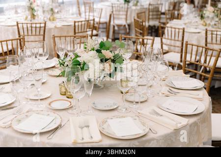 Elegante Tische mit Blumen und Glaswaren sorgen für eine einladende Stimmung für die Feier. Stockfoto