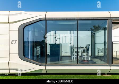 Almancil, Algarve - Portugal - 19.09.2024: Nahaufnahme des modularen Gebäudes E7 mit großer Glasfront, minimalistischer Inneneinrichtung, Esstisch, Waschbecken, umgeben Stockfoto