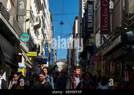 Touristen und Shopper schlendern entlang der Ermou-Straße im Zentrum von Athen, Griechenland. Stockfoto