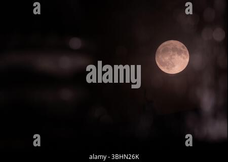 Stuttgart, Deutschland. Juni 2025. Der Mond kann durch das Wasser eines Brunnens gesehen werden. In der Nacht vom 10. Auf den 11. Juni taucht ein seltenes Himmelsphänomen auf: Der Erdbeermond. Der Vollmond ist dann ungewöhnlich tief am Himmel - so tief wie vor 18 Jahren. Quelle: Markus Lenhardt/dpa/Alamy Live News Stockfoto