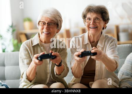 Zwei ältere Freundinnen oder Schwestern spielen zu Hause Videospiele. Stockfoto