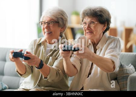 Zwei ältere Freundinnen oder Schwestern spielen zu Hause Videospiele. Stockfoto