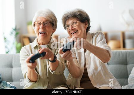 Zwei ältere Freundinnen oder Schwestern spielen zu Hause Videospiele. Stockfoto