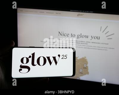 Stuttgart, Deutschland - 20.03.2025: Person mit Smartphone mit Logo des deutschen Kollagenunternehmens Glow25 (Primal) auf dem Bildschirm vor der Website. Stockfoto