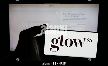 Stuttgart, Deutschland - 20.03.2025: Person mit Mobiltelefon mit Logo des deutschen Kollagenunternehmens Glow25 (Primal) auf dem Bildschirm vor der Webseite. Stockfoto