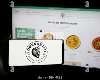 Stuttgart, Deutschland - 20.03.2025: Person mit Smartphone mit Logo des deutschen Bio-Lebensmittelunternehmens Loewenanteil GmbH auf dem Bildschirm vor der Website. Stockfoto