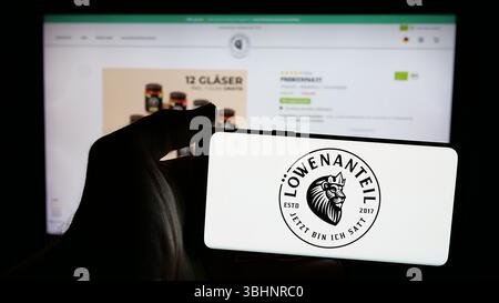 Stuttgart, Deutschland - 20.03.2025: Person mit Mobiltelefon mit Logo des deutschen Bio-Lebensmittelunternehmens Löwenanteil GmbH auf dem Bildschirm vor der Webseite. Stockfoto