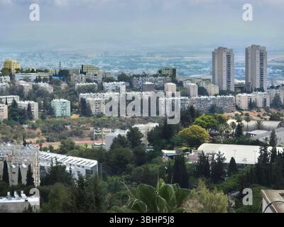 Städtisches Viertel mit Wohngebäuden und Grünanlagen, mit Doppeltürmen und Bergkulisse, die sich zu einem fernen Horizont hin erstreckt. Stockfoto
