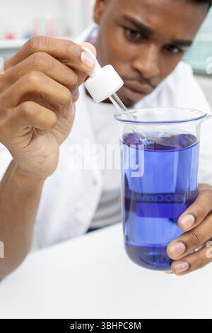 Der Chemiker man verwendet eine Pipette, um die Flüssigkeit in ein Flaschenglas zu füllen Stockfoto