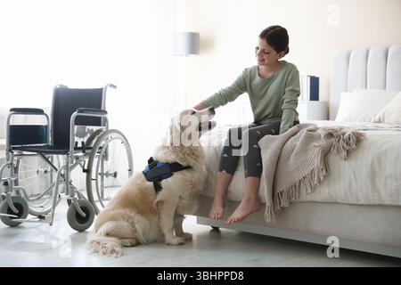 Mädchen mit Behinderung und ihr Diensthund zu Hause Stockfoto