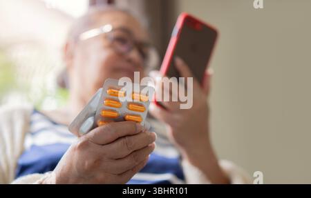 Ältere Frau, die Medizin Pillen mit digitalen Tablet, um Videokonferenzanruf zum Arzt, Apotheke Beratung über medizinische Gesundheitsversorgung für Re Stockfoto