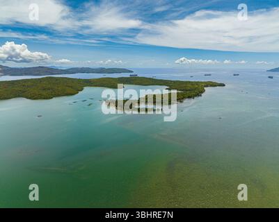 Tropische Insel Meeresbucht mit Fracht und Handelsschiff. Blauer Himmel und Wolken. Mindanao, Philippinen. Stockfoto
