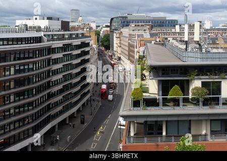 Ein Blick auf Holborn in London, Großbritannien, mit dem BT Tower im Hintergrund. Menschen und Busse bewegen sich entlang der Straße. Stockfoto