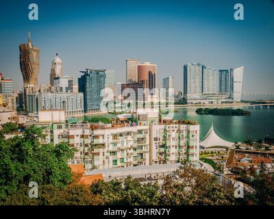 Stadtbild Von Macau Von Oben: Farbenfrohe Dächer Des Historischen Viertels, Die Sich In Hochhäuser Und Hafenaktivitäten Über Das Wasser Verbinden Stockfoto
