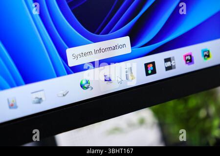 Posen, Polen - 6. Juni 2025: Nahaufnahme eines Computerbildschirms mit der Taskleiste und einem Mauszeiger, der auf das Symbol „Systeminformationen“ zeigt, Abbildung Stockfoto