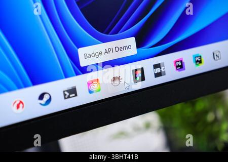 Poznan, Polen – 6. Juni 2025: Detaillierte Ansicht des Computerbildschirms mit Mauszeiger zur Aktivierung der Badge-API Demo-QuickInfo zur Betriebssystem-Taskba Stockfoto