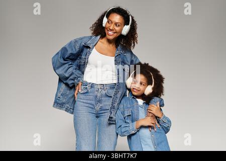 Eine afroamerikanische Mutter und Tochter, die Denim tragen, teilen einen liebevollen Moment. Stockfoto