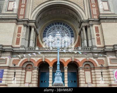 London, Großbritannien - 09. Juni 2025 - Blaue Stangenlaternen vor der Südfassade mit dem Rosenfenster des Alexandra Palace, das ursprünglich „The P Stockfoto