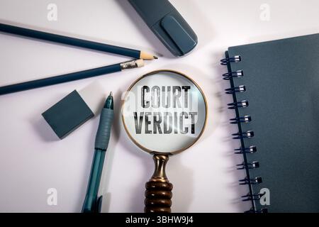 Gerichtsurteil Text unter Lupenglas mit Bürobedarf auf weißem Hintergrund. Stockfoto