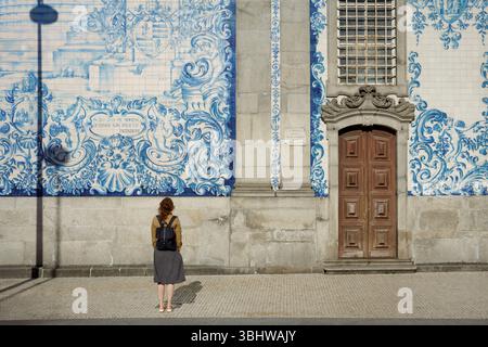 Frau mit Blick auf die blaue Azulejos-Fassade von Igreja do Carmo, Porto Reiseattraktion Stockfoto