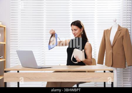 Professioneller Stylist mit Online-Beratung mit Kunden über Laptop im Innenbereich Stockfoto