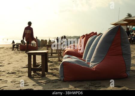 Bali, Indonesien - 20. Mai 2025: Sitzsäcke und Holztische am Strand Stockfoto