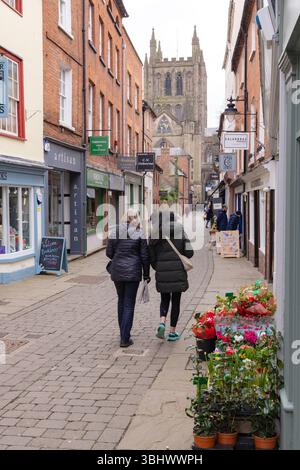 Stadtzentrum von Hereford, Hereford UK; zwei Frauen laufen im Frühjahr durch enge Gassen zur Kathedrale; Stockfoto