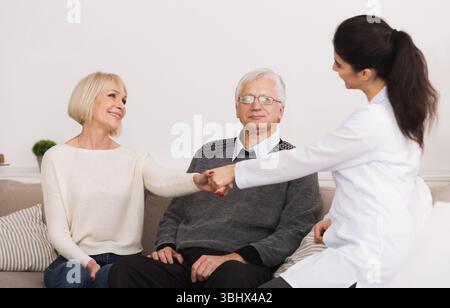 Senior Paar einladende Doktor während Home Besuch Stockfoto