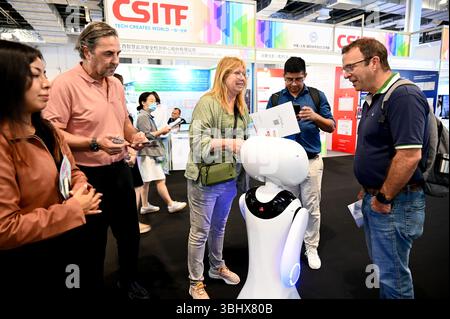 SHANGHAI, CHINA - 11. JUNI 2025 - Besucher kommunizieren mit Robotern auf der China (Shanghai) International Technology Fair (CSITF) am 11. Juni 2025 in Shanghai, China. Stockfoto
