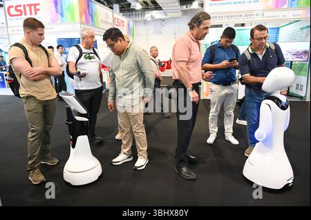 SHANGHAI, CHINA - 11. JUNI 2025 - Besucher kommunizieren mit Robotern auf der China (Shanghai) International Technology Fair (CSITF) am 11. Juni 2025 in Shanghai, China. Stockfoto