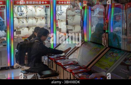 Zwei Kinder spielen ein Spiel in einer Spielhalle in Asakusa Tokio Japan Stockfoto
