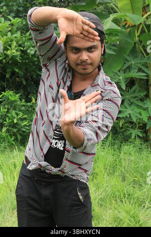 Ein müder junger Arbeiter, der gestresst und erschöpft aussieht, mit der Hand auf dem Kopf an einem heißen Sommertag. Steht für Not und das Leben eines Arbeiters. Stockfoto