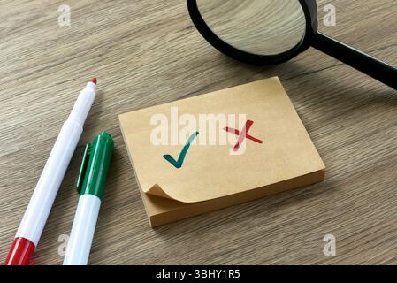 Checkliste mit grünem Häkchen und rotem Kreuz auf Haftnotiz mit Stiften. Stockfoto